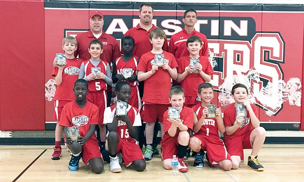 The Austin fourth grade boys basketball team finished in first place in the Austin tournament Feb. 21. Back row (left to right): coach Dan Ransom, coach Brian Schneider, and coach Jeremy Herrick; middle row: Peyton Ransom, Isaac Osgood, Ater Manyuon, Mason Pacholl, and Brenden Moriarty; front row:  Cham Okey, Jenup Chop, Christopher Schneider, Jacob Herrick and Joe Ewing. Photo Provided