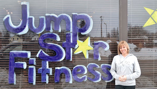 Julie Olson stands outside Jump Star Fitness, her new gym which held its grand-opening Saturday. Olson is donating half of what she makes to cancer research in honor of her mother. -- Jenae Hackensmith/jenae.hackensmith@austindailyherald.com