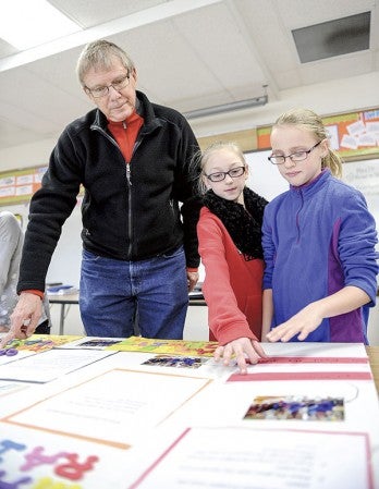Kailee Aldrich, right, and partner Hailey Schmitz go over their project with mentor Fred Bogott as they prepare for today’s science fair Thursday afternoon at Neveln Elementary. Eric Johnson/photodesk@austindailyherald.com
