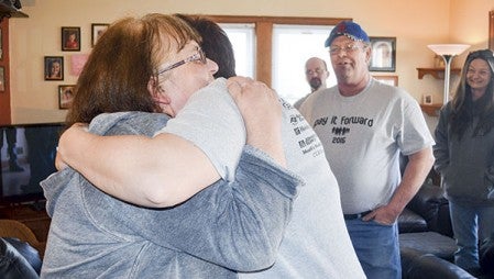 Marsha Wilde gives Gina Grundmeier of T ‘N G Plumbing a hug Friday at the end of T ‘N G’s Pay It Forward bathroom remodel project. Marsha and her husband, Gary, in the background, received a bathroom remodel, all new plumbing and more as part of the project.  Trey Mewes/trey.mewes @austindailyherald.com