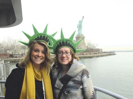 Chelsey Benz (left) and Kimberly Schiltz stand in front of the Statue of Liberty in New York City. They were part of a larger group of 20 students and community members who went to New York City through a trip organized by Riverland Community College to help the travelers see new culture and have new experiences. Photo provided.