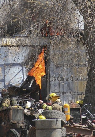 Flames spark up as firefighters look for hotspots while responding to a shed fire on the north side of Lansing Friday. Jason Schoonover/jason.schoonover@austindailyherald.com
