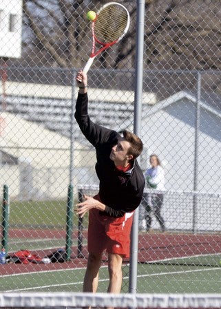 Austin's Jeremy Olmsted makes a serve against Albert Lea in Paulson tennis courts Monday. Rocky Hulne/sports@austindailyherald.com