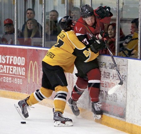 Will Hammer, of the Aberdeen Wings, right, gets pushed into the boards by Jade Miller, of the Austin Bruins, left, during the first period of Friday night's playoff game at the Odde Ice Center. Photo by John Davis/Aberdeen News