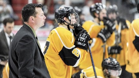 Austin Bruins head coach Chris Tok stands with his team and watches as the Robertson Cup is presented to the Minnesota Wilderness Saturday night at Riverside Arena.
