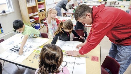 Woodson Kindergarten teacher Jason Denzer gets students organized for a project Wednesday morning. 