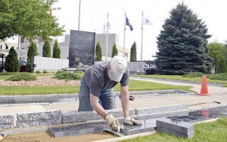 Anderson Memorial owner Jeff Anderson places a batch of 55 pavers at the Mower County Veterans Memorial Friday afternoon in preperation for Memorial Day. After a string of sales, 1,028 pavers have sold and the project is nearing the goal of 1,056 pavers. Jason Schoonover/jason.schoonover@austindailyherald.com