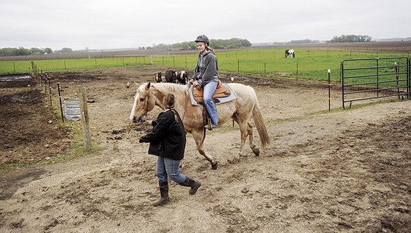 Clippity-Clop Riding Center owner Angela Grant leads Austin Daily Herald reporter Jenae Hackensmith on Buck during a riding lesson.  Eric Johnson/photodesk@austindailyherald.com