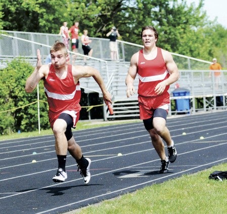 Tyler Olson takes a hand-off from from Jon Gallagher in the 4 x 200-meter relay at the Big Nine track and field meet in Mankato East Friday. Adam Holt/Faribault Daily News