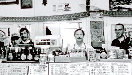 Robert Knauer stands with two of his sons and one grandson in Knauer’s Meat Market. The market has not changed much since it first opened over a century ago. Photo provided