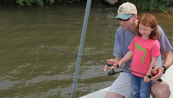 Jason Baron, from left, fishes with his daughter, Jacey during the Austin Jaycees Take a Kid Fishing Day event last year at East Side Lake Park. This year’s event starts at 11 a.m. Saturday. Herald file photo