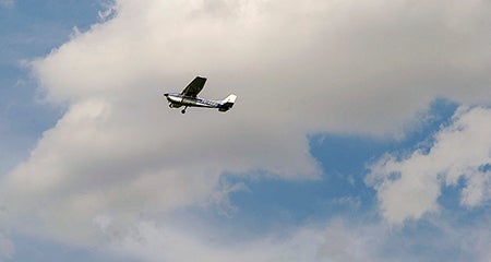 A plane carrying 9-year-old Scott Wentworth flies over Austin Municipal Airport.