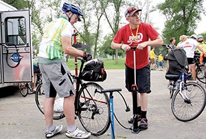 ABOVE: Mike Weiss of Penn Cycle & Fitness talks with a rider as helps another rider fix a tire at Todd Park. 