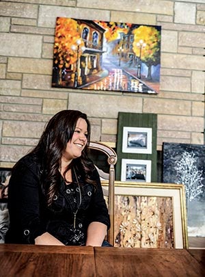 Artist Danielle Jondal sits with several of her pieces as she talks about her art and inspiration. Eric JOhnson/photodesk@austindailyherald.com