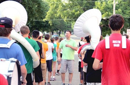 Director Brad Mariska talks to members of the Austin High School band on Fifth Street Northwest Tuesday during a practice for the Fourth of July Parade. Jason Schoonover/jason.schoonover@austindailyherald.com