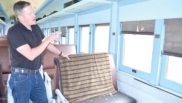 Mower County Historical Society Executive Director John Haymond points out damage done by vandals to the Milwaukee Railroad train Thursday afternoon. While the train's windows can be replaced, items like the train's original blinds will likely be permanently damaged. 