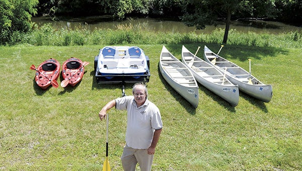 Brian Pirmantgen stands with his fleet of kayaks, a paddleboat and canoes that will soon be available for rent.  Eric Johnson/photodesk@austindailyherald.com