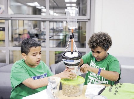 Erick Hernandez, left, of Austin and Dakota Robinson of Hayfield assemble a water-filtration unit as part of Project E3 Thursday at I.J. Holton Intermediate School. Photos by Eric Johnson/photodesk@austindailyherald.com