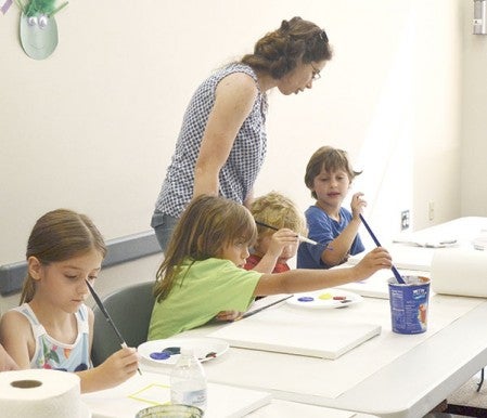 Children paint different shapes and objects on their canvases at the Austin Public Library Monday.  Jenae Hackensmith/jenae.hackensmith@austindailyherald.com