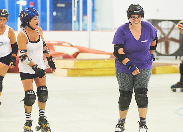 Shell 'Shell on Wheels' Johnson (left) and Ashley 'Ashkicker' Crump skate during a practice for the Southbound Rollers in Packer Arena Monday. Rocky Hulne/sports@austindailyherald.com
