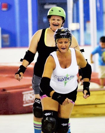 Angela 'Bubble Wrap Bandit' HIggins (front) and Shana 'Sister No Mercy' Williams skate in a Southbound rollers practice in Packer Arena Tuesday. Rocky Hulne/sports@austindailyherald.com