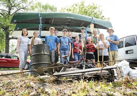 A group of volunteers stand in front of the trash they pulled out of Mill Pond Friday as part of the Water Festival. Eric JOhnson/photodesk@austindailyherald.com