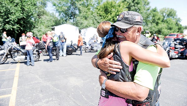 Steve “Sully” Sullivan gets a hug from Jamie Wenninger before the American Legion Riders leave the Austin American Legion parking lot to continue the 2015 Legacy Run Saturday.  Photos by Eric Johnson/photodesk@austindailyherald.com