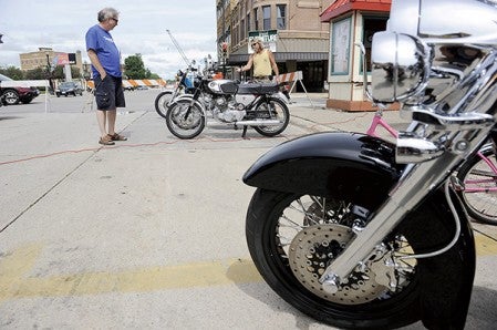 Bob Larson, left and Reed Cowan, visiting from California, look over bikes at the Spare Parts Motorcycle Show during the Austin ArtWorks Festival last year. Herald file photo
