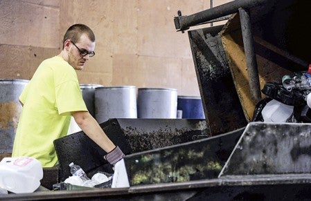 Tim Bush sorts through plastic as it is unloaded at the recycling center. Bush is one of several Cedar Valley clients whose jobs are being threatened if the county moves to single-sort recycling. Eric Johnson/photodesk@austindailyherald.com