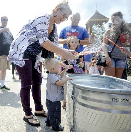 Angela Perry helps her son Ashton Perry, one-and-a-half, load up on bubbles.