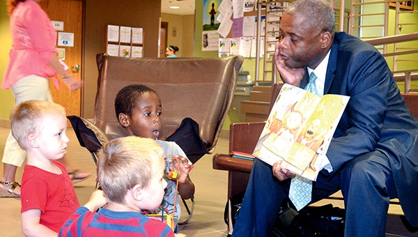 Minnesota Department of Human Rights Commissioner Kevin Lindsey reads to Alex Bure (left) Jayce Simmons and Dionte Oman Tuesday afternoon at the Mower County Government Center Reading Oasis. -- JenaeHackensmith/jenae.hackensmith@austindailyherald.com