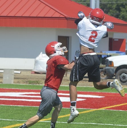 Elijah Andersen leaps over Nate Conner to haul in a pass in Austin football practice in Art Hass Stadium Wednesday. Rocky Hulne/sports@austindailyherald.com