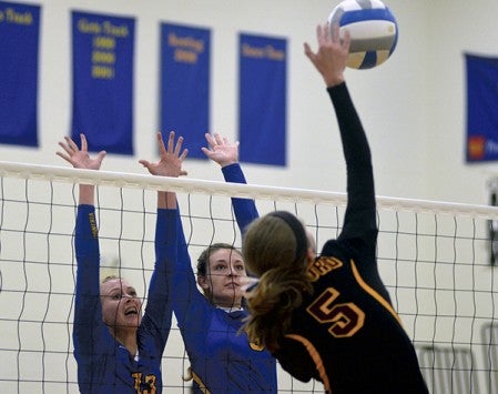 From left: Hayfield's Madison Booms and Savanna Cordle defend the net on a hit by Medford's Taya Sexton in Hayfield Monday. Rocky Hulne/sports@austindailyherald.com
