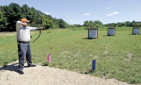 Mike Gehrke zeros in on one of the targets at the archery range in Adams.  Eric Johnson/photodesk@austindailyherald.com