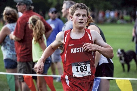 Austin’s Brockdon Lawhead glances over at his time as he crosses the finish line during the boys race of the Austin Invitational cross country race Tuesday afternoon at Meadow Greens Golf Course. Eric Johnson/photodesk@austindailyherald.com