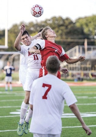 Austin’s Sam Ewing contends for a header with Mankato West’s Jacob Makela during the first half Thursday night at Art Hass Stadium. Eric Johnson/photodesk@austindailyherald.com