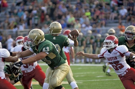 Austin's Jackson Hample, right, closes in on Rochester Mayo quarterback Trajan Grimsrud in Rochester Friday. Rocky Hulne/sports@austindailyherald.com