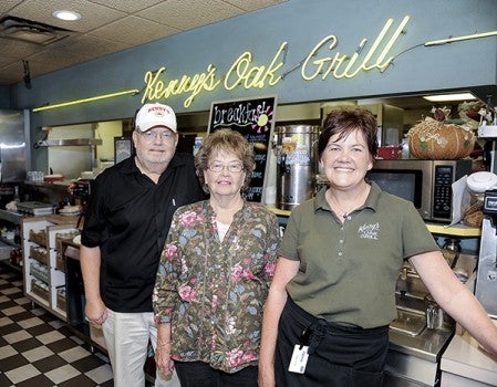 Kenneth and Joanne Knutson and their daughter Kim Mohrfeld, right, stand under the Kenny’s Oak Grill sign Friday morning. The family has had a long run with the popular restaurant, open these past 50 years.  Eric Johnson/photodesk@austindailyherald.com