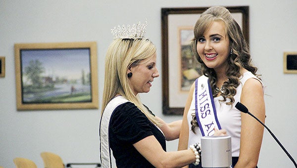 Mrs. Minnesota 2015 Kate Howe, left, gives Miss Austin 2016 Kaylee Kalbow her banner during the Austin City Council meeting Monday night in the council chambers.  Jason Schoonover/jason.schoonover@austindailyherald.com