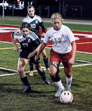 Austin’s Erin Bickler controls the ball in front of Jade Bokman (17) and Payton Putrah (10) during their Section 2A first-round game Tuesday night at Art Hass Stadium. Eric johnson/photodesk@austindailyherald.com