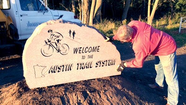 Anderson Memorial’s Jeff Anderson installs a granite monument near 21st Street Northeast on the Shooting Star Trail as a welcome to Austin. -- Photos provided by Renee Anderson