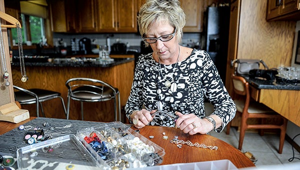 Amy Lanorgen works on some of her jewelry from her dining room. -- Photos by EricJohnson/photodesk@austindailyherald.com