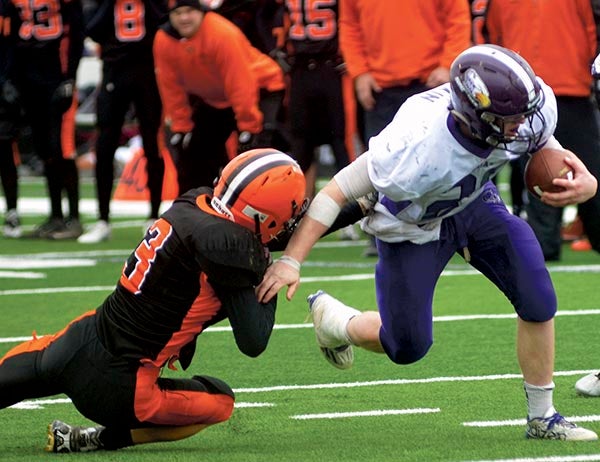 Grand Meadow's Christophor Bain muscles out of a tackle attempt by Brock Arndt of Cleveland in New Prague Saturday. Rocky Hulne/sports@austindailyherald.com