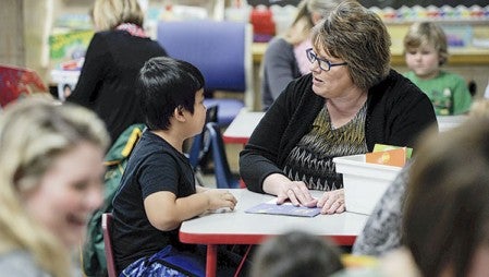  Hormel employee Janice Christianson reads with Johnathan Htoo.
