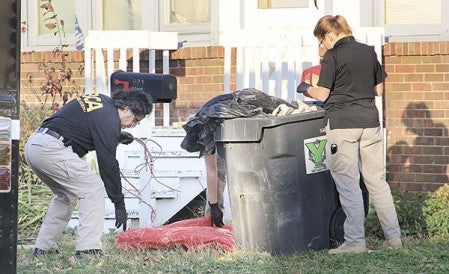 Investigators with the Minnesota Bureau of Criminal Apprehension take evidence from a trash bin outside a home on the 400 block of South Main Street in Austin Thursday afternoon. Jason Schoonover/jason.schoonover@austindailyherald.com