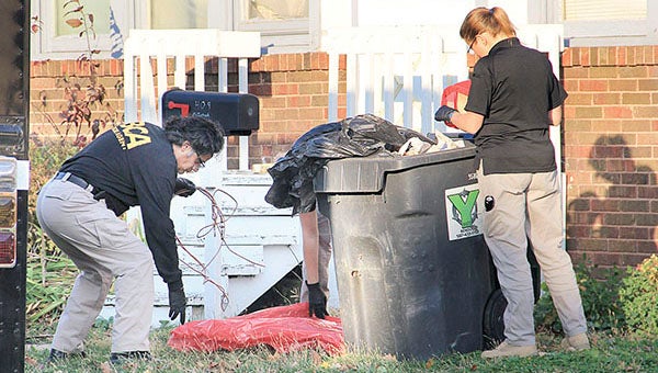 Investigators with the Minnesota Bureau of Criminal Apprehension take evidence from a trash bin outside a home on the 400 block of South Main Street in Austin Thursday afternoon. Jason Schoonover//jason.schoonover@austindailyherald.com