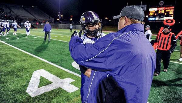 Grand Meadow’s Brenn Olson is greeted by assistant coach Aaron Myhre as the Superlarks wrapped up their fourth-straight trip to the Minnesota Class Nine Man State Football Tournament, defeating Waubun in the semifinals in St. Cloud Saturday night. -- Eric Johnson/ photodesk@austindailyherald.com