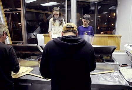 Anna and Owen Kossman watch pizzas being made Wednesday night at George’s Pizza. The popular vantage point for kids was a holdover from the original restaurant.  Photos by Eric Johnson/photodesk@austindailyherald.com