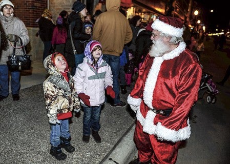 Santa Claus stops to talk to four-year-old Eastyn Gardner and his six-year-old sister Payton Gardner of Rose Creek before helping kick off Christmas in the City Friday night on Main Street. Eric Johnson/photodesk@austindailyherald.com