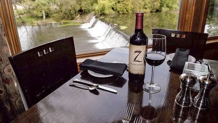 ABOVE: A bottle of The Seven Deadly Zins graces a table looking out over the Cedar River at the The Old Mill Restaurant. 